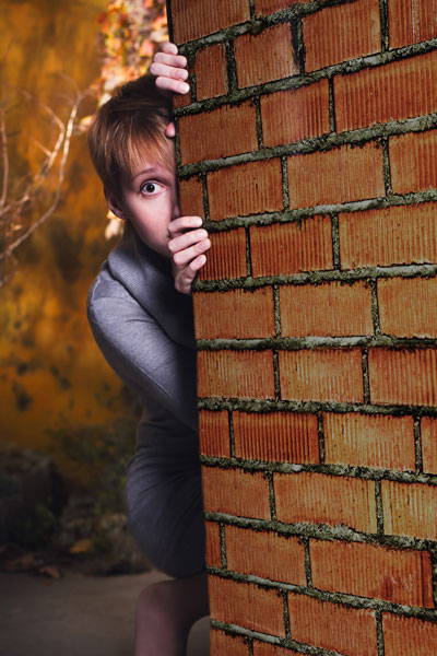 woman-hiding-behind-wall